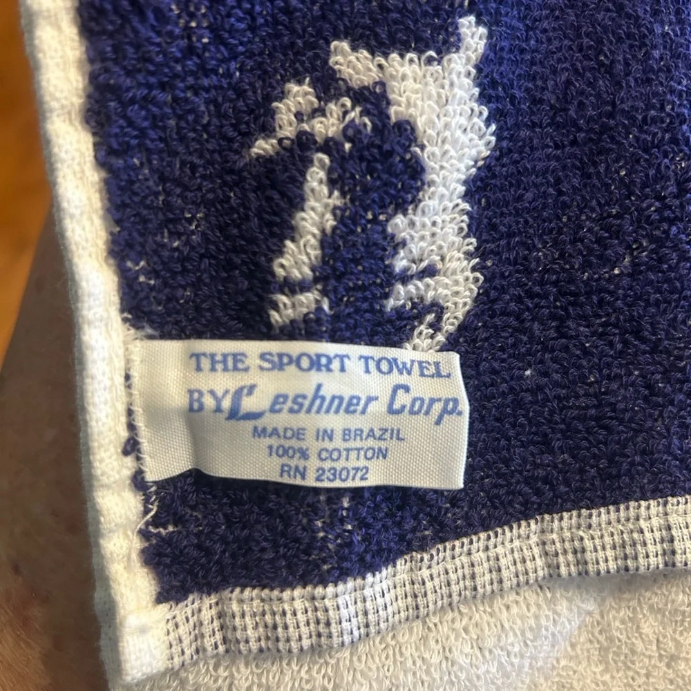 2 sports towels. 1 is reversible and has a tennis player. 1 is izod brand.
